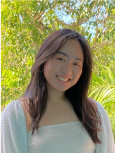 A student with long straight brown hair wearing a light blue cardigan