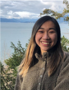 A student standing on a bluff over the ocean